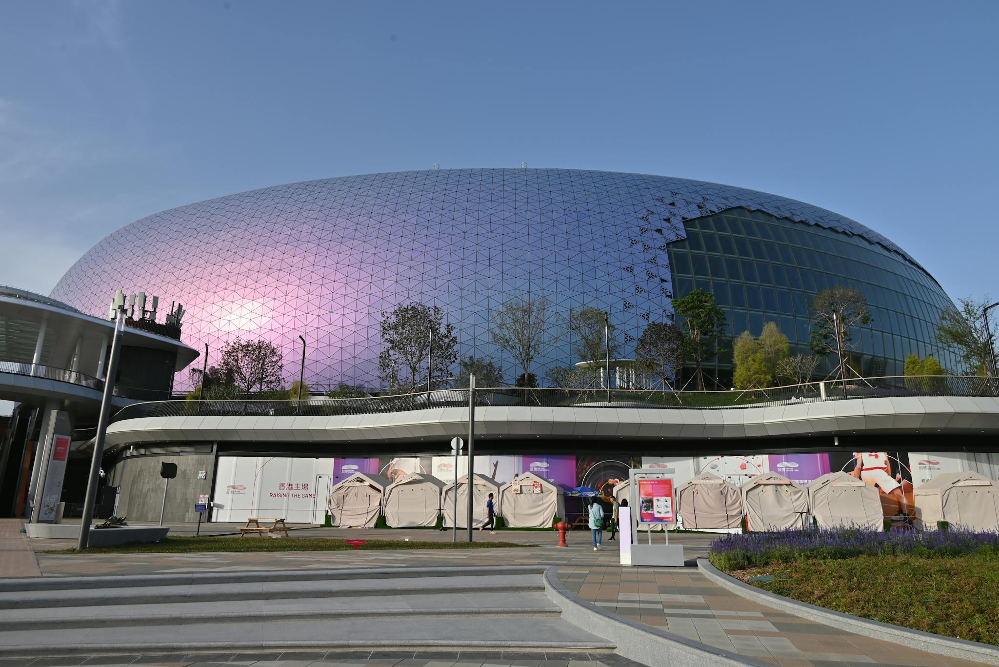 Modern dome-shaped building with reflective glass facade in urban setting.